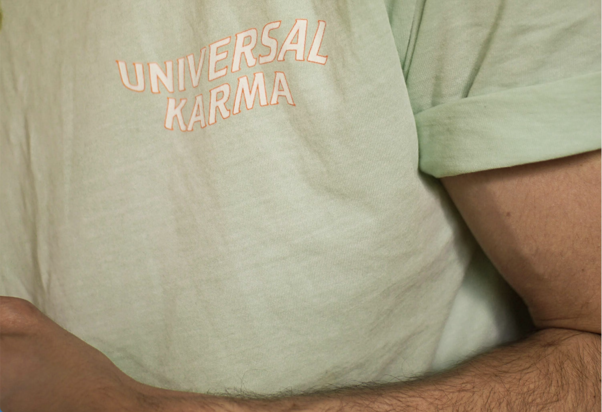 masculine arm of a man wearing green t-shirt