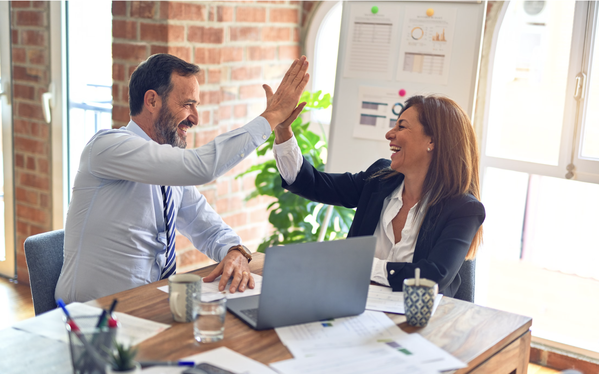 two executives, man and woman celebrating success