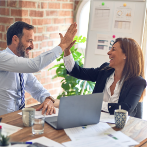 two executives, man and woman celebrating success